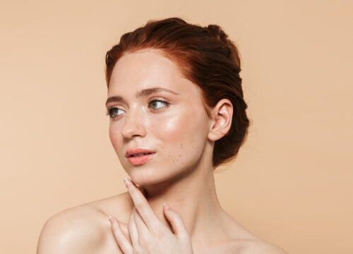 Woman with red hair showing off skin that has clarity