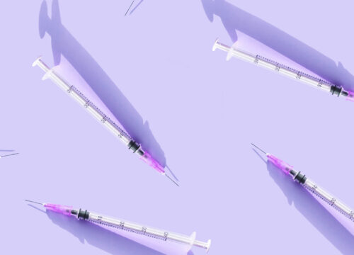 Injectable needles spread across a purple background