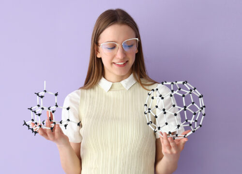 Woman holding science models on a purple background