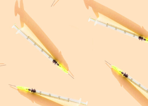 Injectable syringes on a yellow background