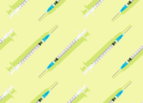 Injectable syringes on a bright yellow green background