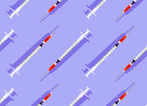 Injectable syringes lined up diagonally on a purple background