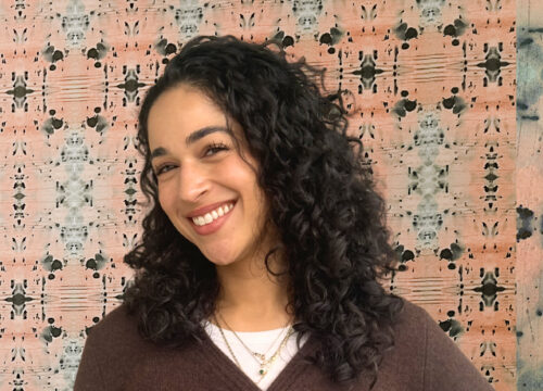 Headshot of Kristen on a wallpapered background