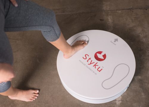 Woman stepping on Styky 3D body scanner
